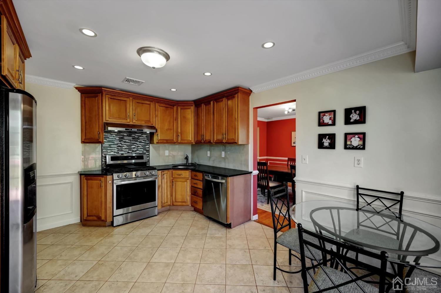 481 Plainfield Road Edison, NJ 08820 - Photo 13 of 42 a kitchen with stainless steel appliances granite countertop a stove top oven a sink a dining table and chairs