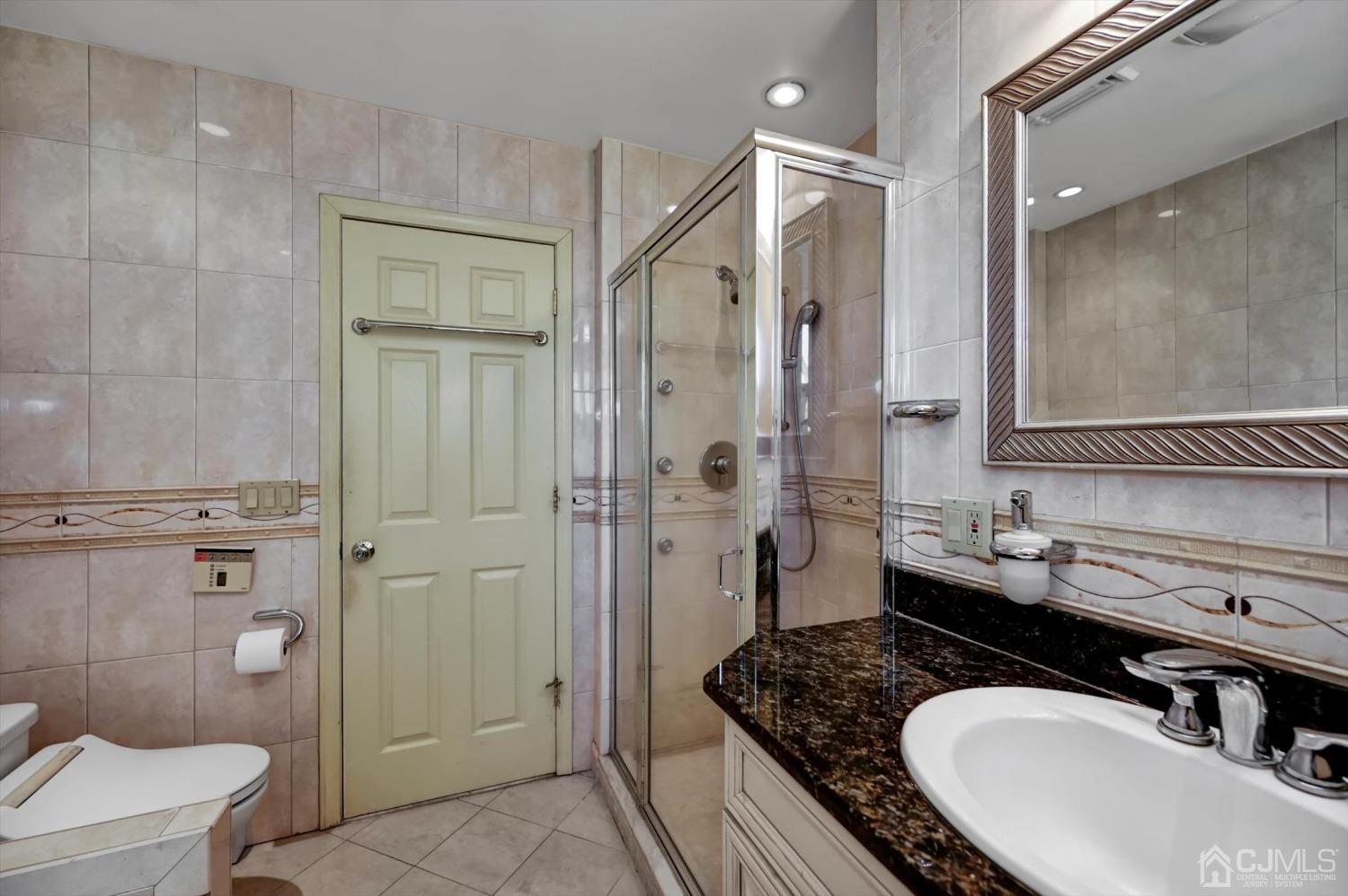 481 Plainfield Road Edison, NJ 08820 - Photo 32 of 42 a bathroom with a granite countertop sink a mirror a toilet and shower