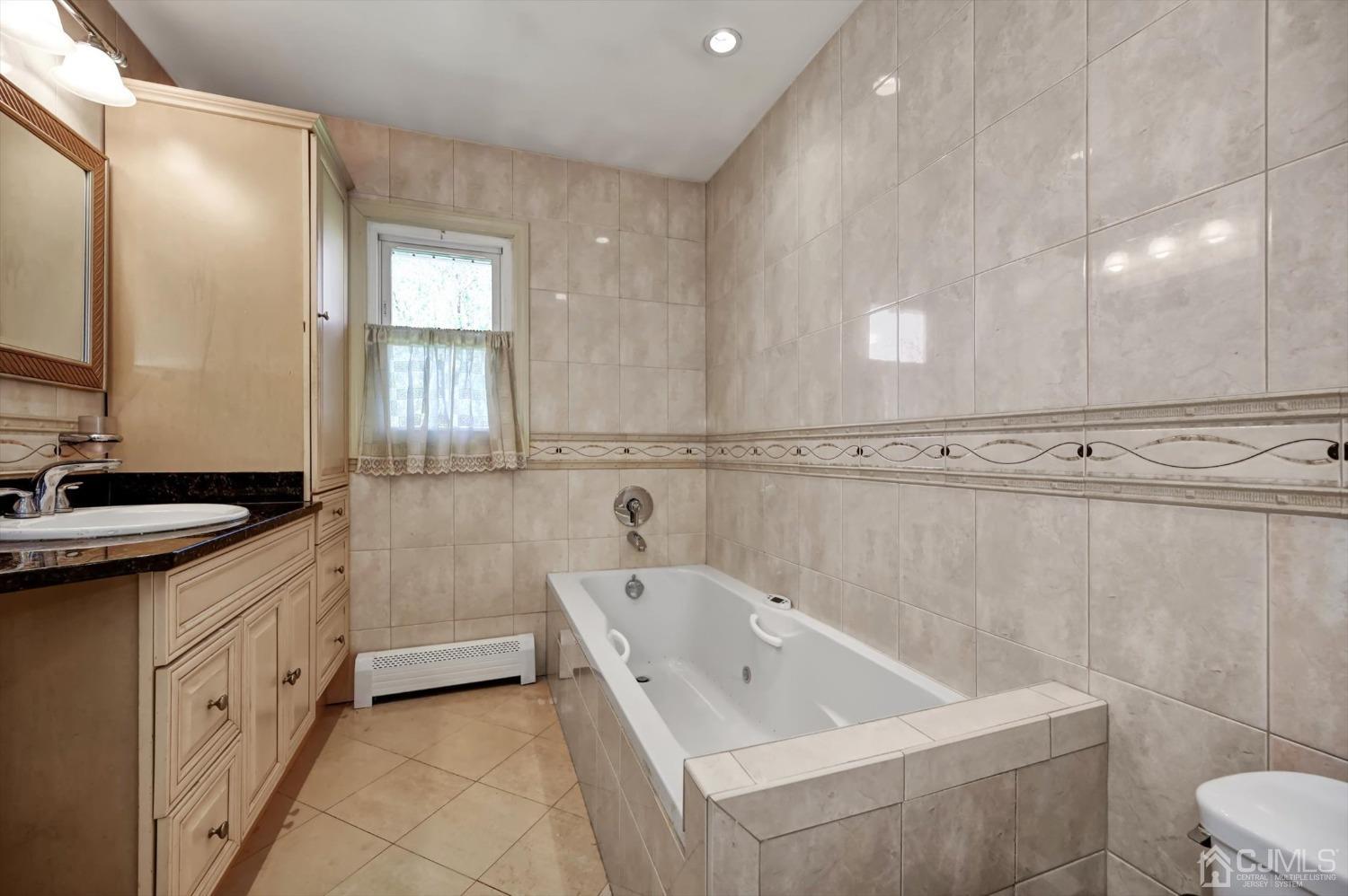 481 Plainfield Road Edison, NJ 08820 - Photo 33 of 42 a bathroom with a bathtub a sink a toilet and a mirror