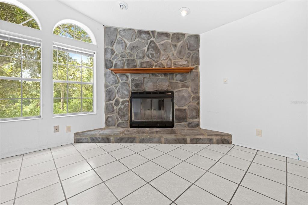 33320 Larkin Road Dade City, FL 33523 - Photo 22 of 60 a living room with a fireplace and a large window