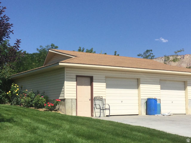1040 West Mill Road Ferron, UT 84523 - Photo 113 of 117 Garage structure with horizontal siding, two overhead garage doors, and a side entry door