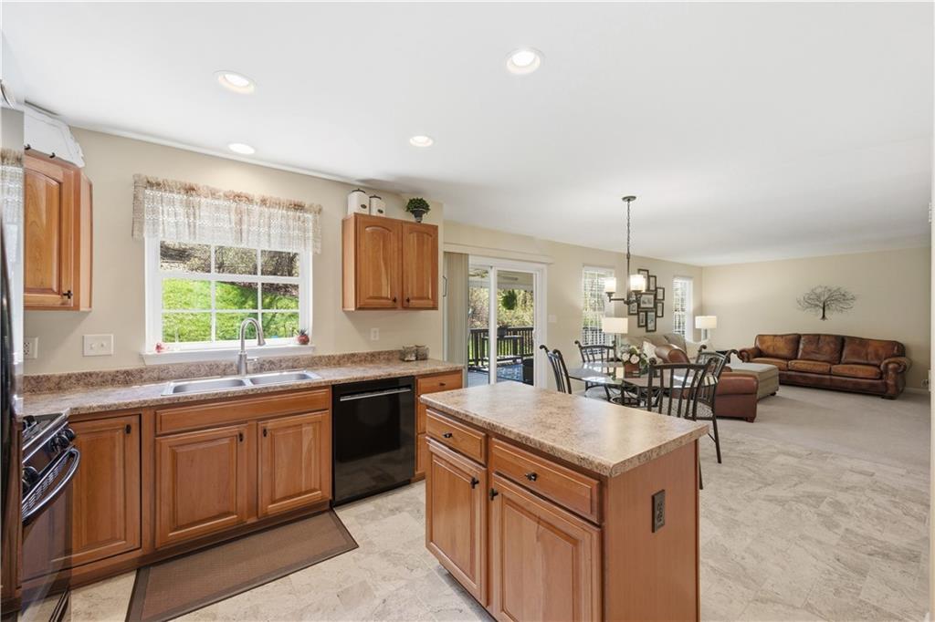 155 Broadstone Drive Mars, PA 16046 - Photo 12 of 30 a kitchen with a stove a sink a kitchen island with chairs and cabinets