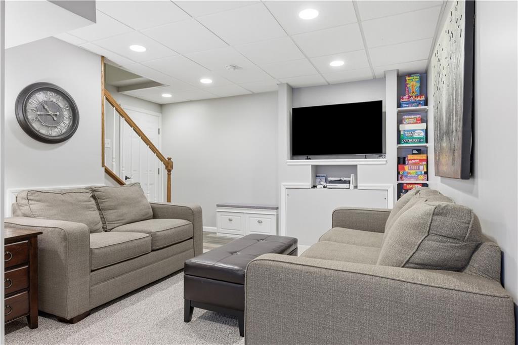 155 Broadstone Drive Mars, PA 16046 - Photo 22 of 30 a living room with furniture a clock and a flat screen tv