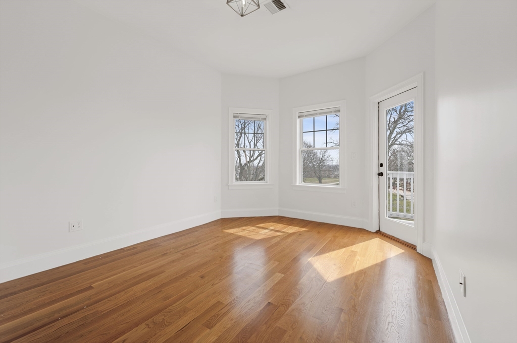 6 Marie Street, Unit 3 Boston, MA 02122 - Photo 12 of 25 a view of an empty room with a window and wooden floor