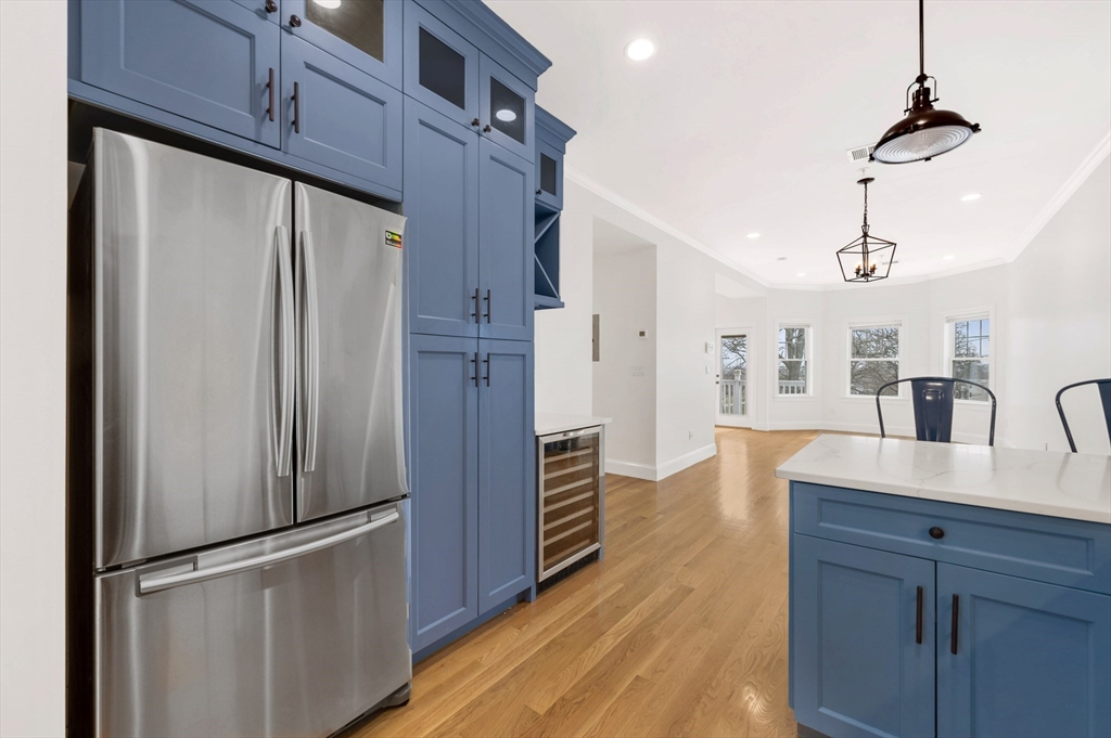6 Marie Street, Unit 3 Boston, MA 02122 - Photo 4 of 25 a kitchen with kitchen island wooden floor appliances and cabinets
