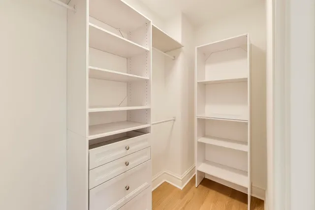 a view of walk in closet with empty racks