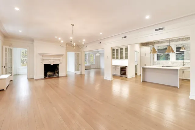 an empty room with wooden floor and fireplace