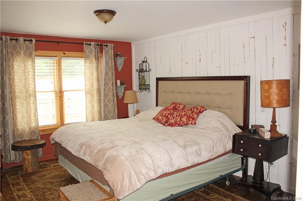 214 Huffman Road Clyde, NC 28721 - Photo 11 of 24 a bedroom with a bed and wooden floor