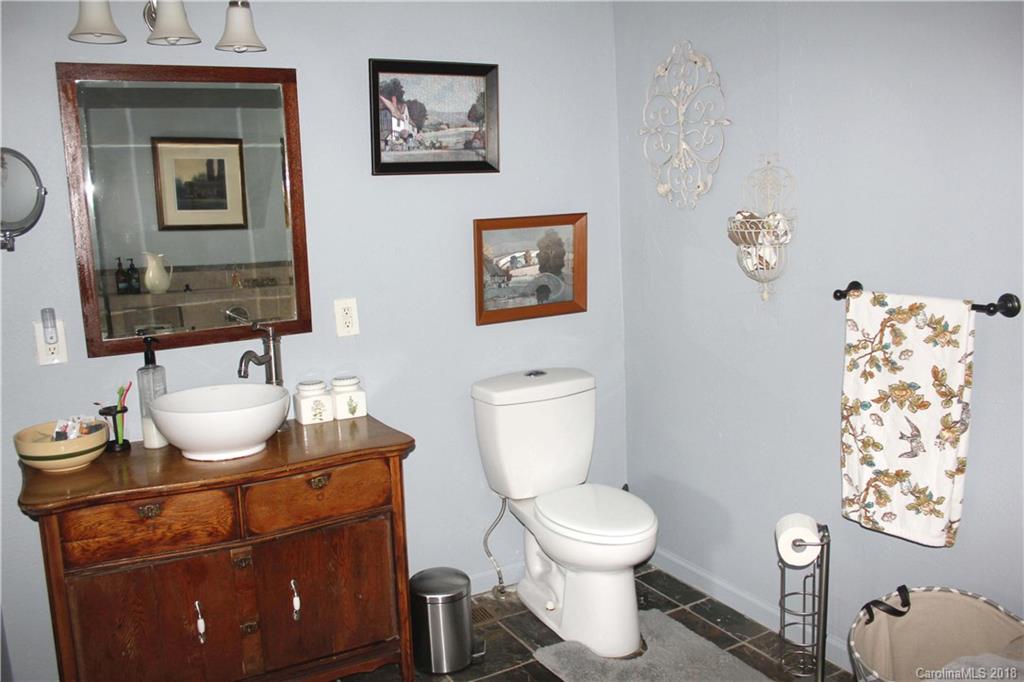 214 Huffman Road Clyde, NC 28721 - Photo 14 of 24 a bathroom with a toilet sink and mirror