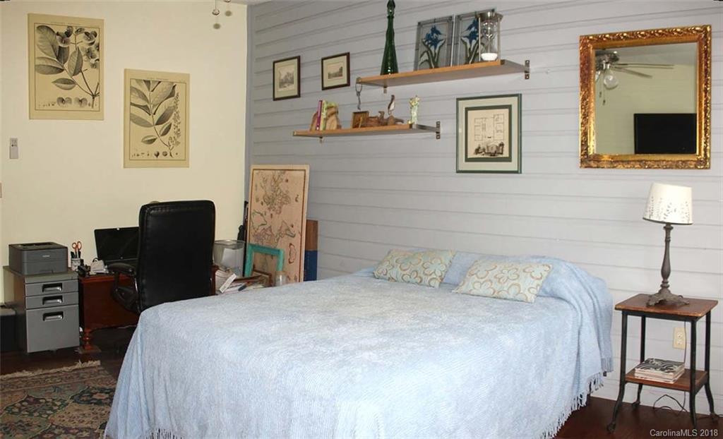 214 Huffman Road Clyde, NC 28721 - Photo 16 of 24 a bedroom with a bed and a lamp on dresser
