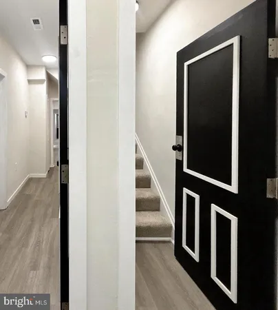 a view of a hallway with wooden floor and staircase