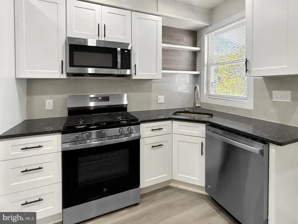 a kitchen with stainless steel appliances granite countertop a stove microwave and oven