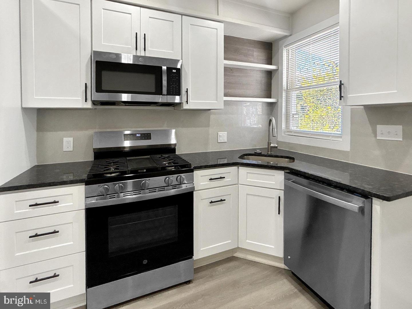 2306 Wichita Avenue Baltimore, MD 21215 - Photo 7 of 18 a kitchen with stainless steel appliances granite countertop a stove microwave and oven