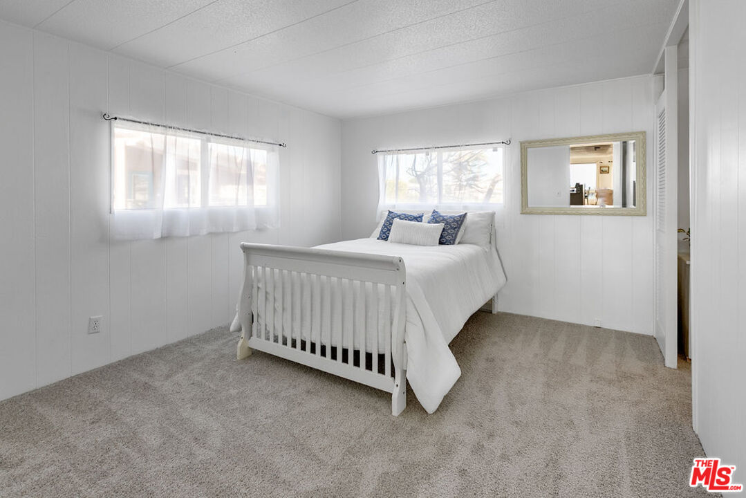 29500 Heathercliff Road, Unit 252 Malibu, CA 90265 - Photo 27 of 65 a bedroom with a bed window and a mirror