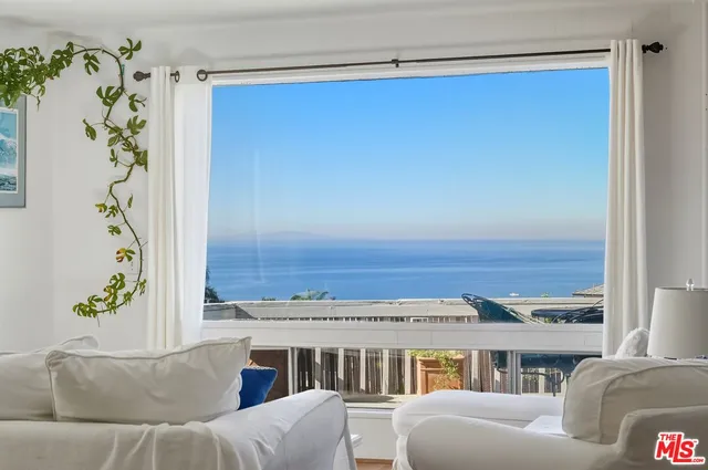 a view of empty room with window and wooden floor