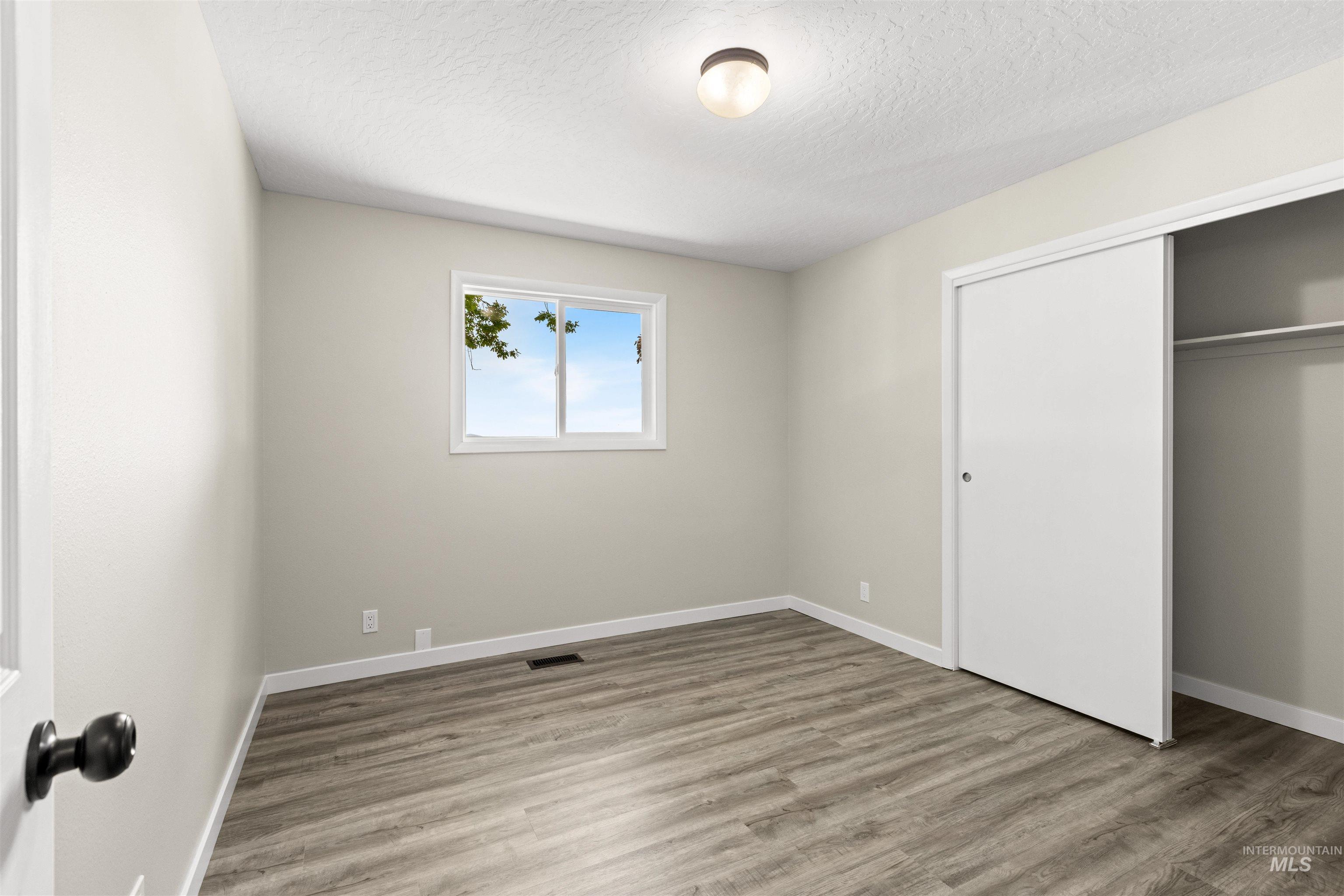12184 Hill Road Payette, ID 83661 - Photo 21 of 35 Neutral-toned room featuring wood-finish flooring and a white trim baseboard