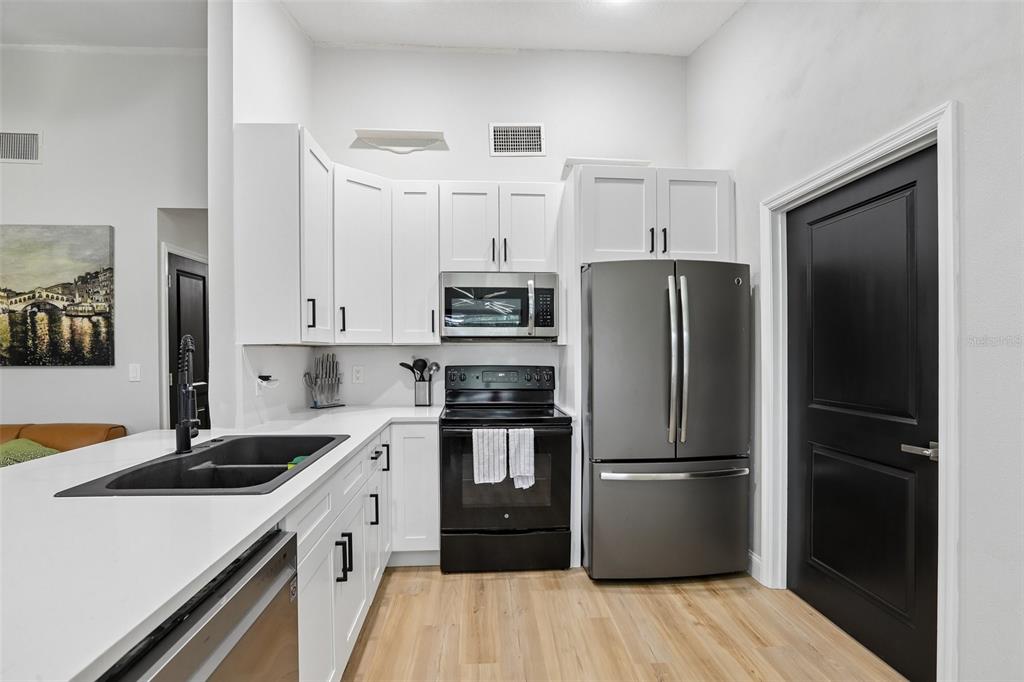 1525 Kestrel Way Brandon, FL 33511 - Photo 9 of 48 a kitchen with a refrigerator sink and wooden floor