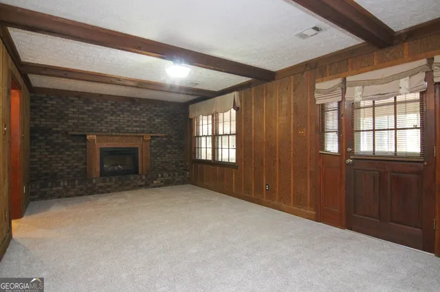a view of an empty room with a fireplace and a window