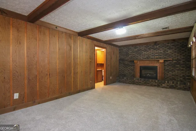 a view of an empty room with a fireplace and a window