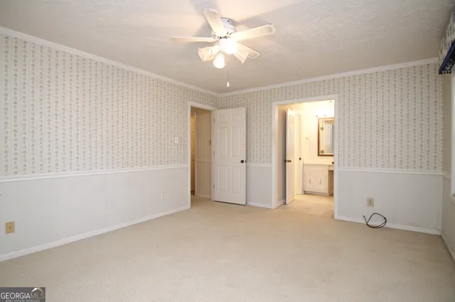 an empty room with a ceiling fan and shower