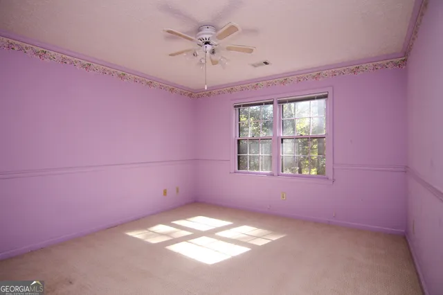 a view of empty room with window and chandelier fan