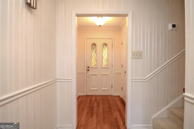a view of a hallway with wooden floor and entryway