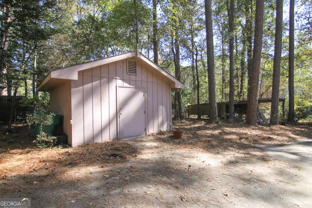 a backyard of a house with large trees and outdoor seating