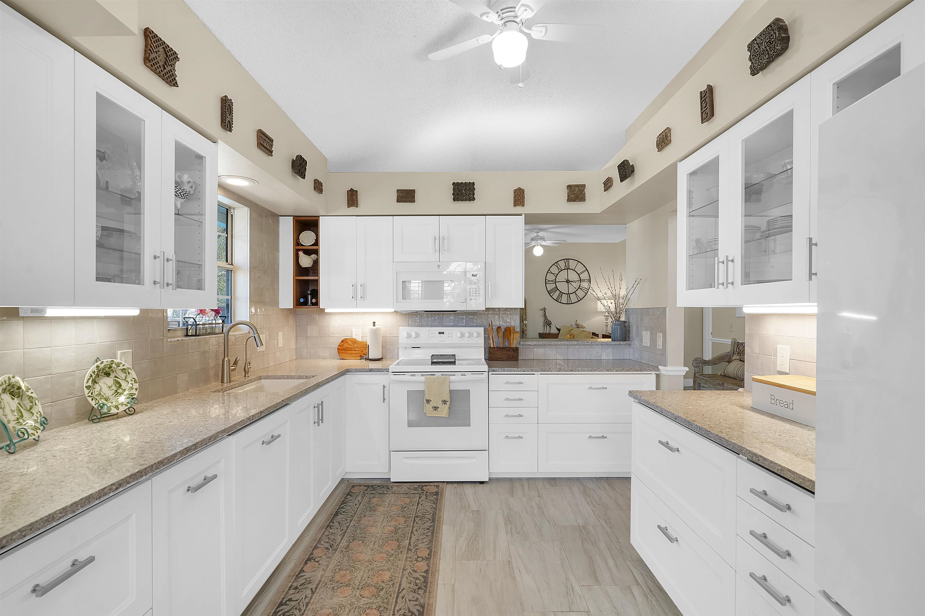 321 Mystical Way St. Augustine, FL 32080 - Photo 14 of 46 Kitchen featuring glass fronted cabinets, white appliances, white cabinetry, and light stone countertops