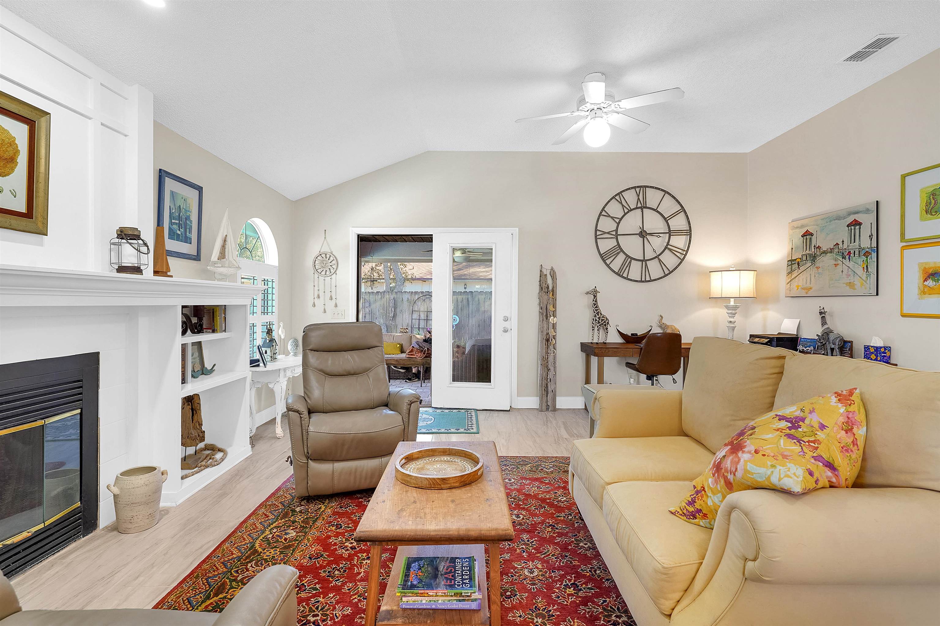 321 Mystical Way St. Augustine, FL 32080 - Photo 17 of 46 Living room with a ceiling fan, lofted ceiling, light wood-style floors, and a glass covered fireplace