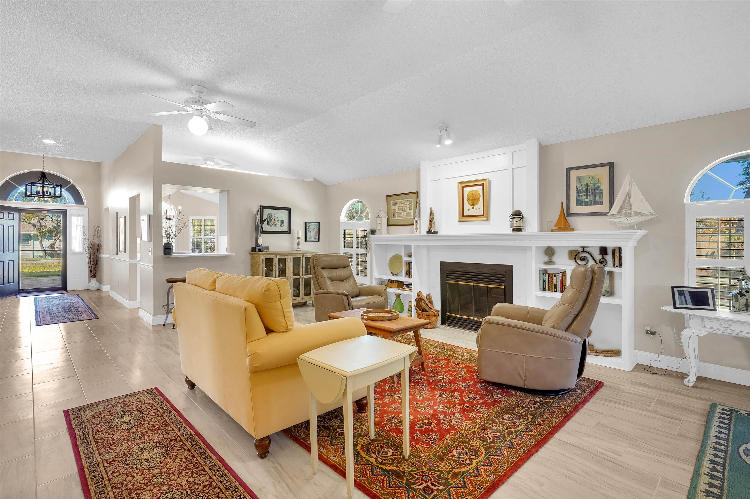 321 Mystical Way St. Augustine, FL 32080 - Photo 18 of 46 Living area featuring ceiling fan, a large fireplace, wood tiled floors, and vaulted ceiling