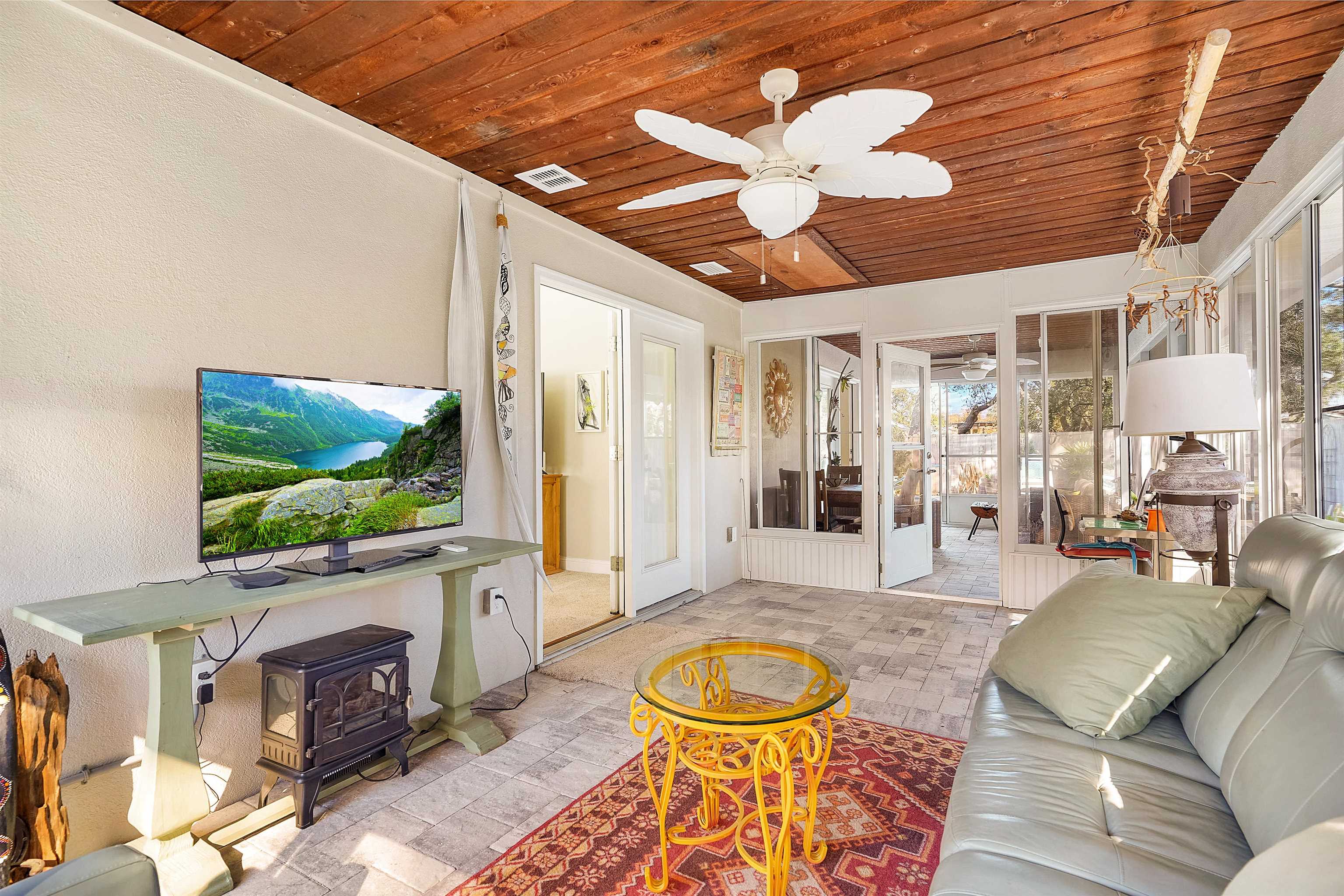 321 Mystical Way St. Augustine, FL 32080 - Photo 25 of 46 Living room with wood ceiling, ceiling fan, and a wood stove