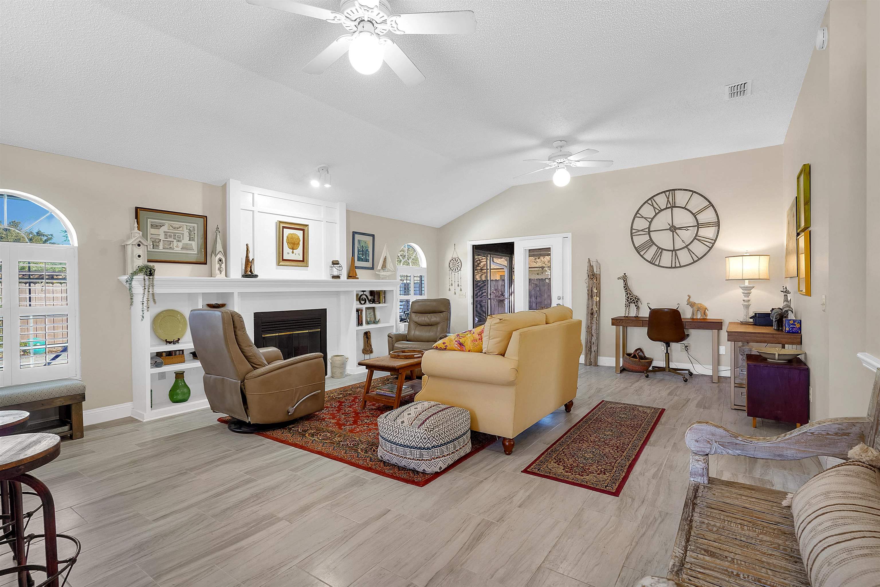 321 Mystical Way St. Augustine, FL 32080 - Photo 4 of 46 Living area featuring vaulted ceiling, a ceiling fan, a fireplace, light wood-style flooring, and healthy amount of natural light