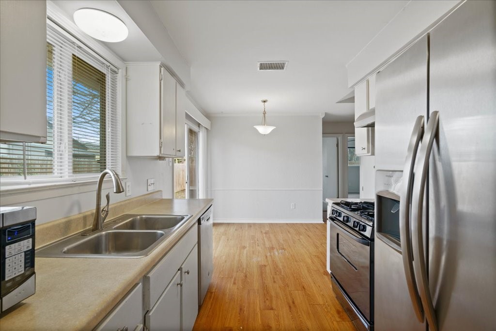 5305 West Gate Boulevard, Unit A Austin, TX 78745 - Photo 1 of 14 a kitchen with stainless steel appliances granite countertop a refrigerator and a sink