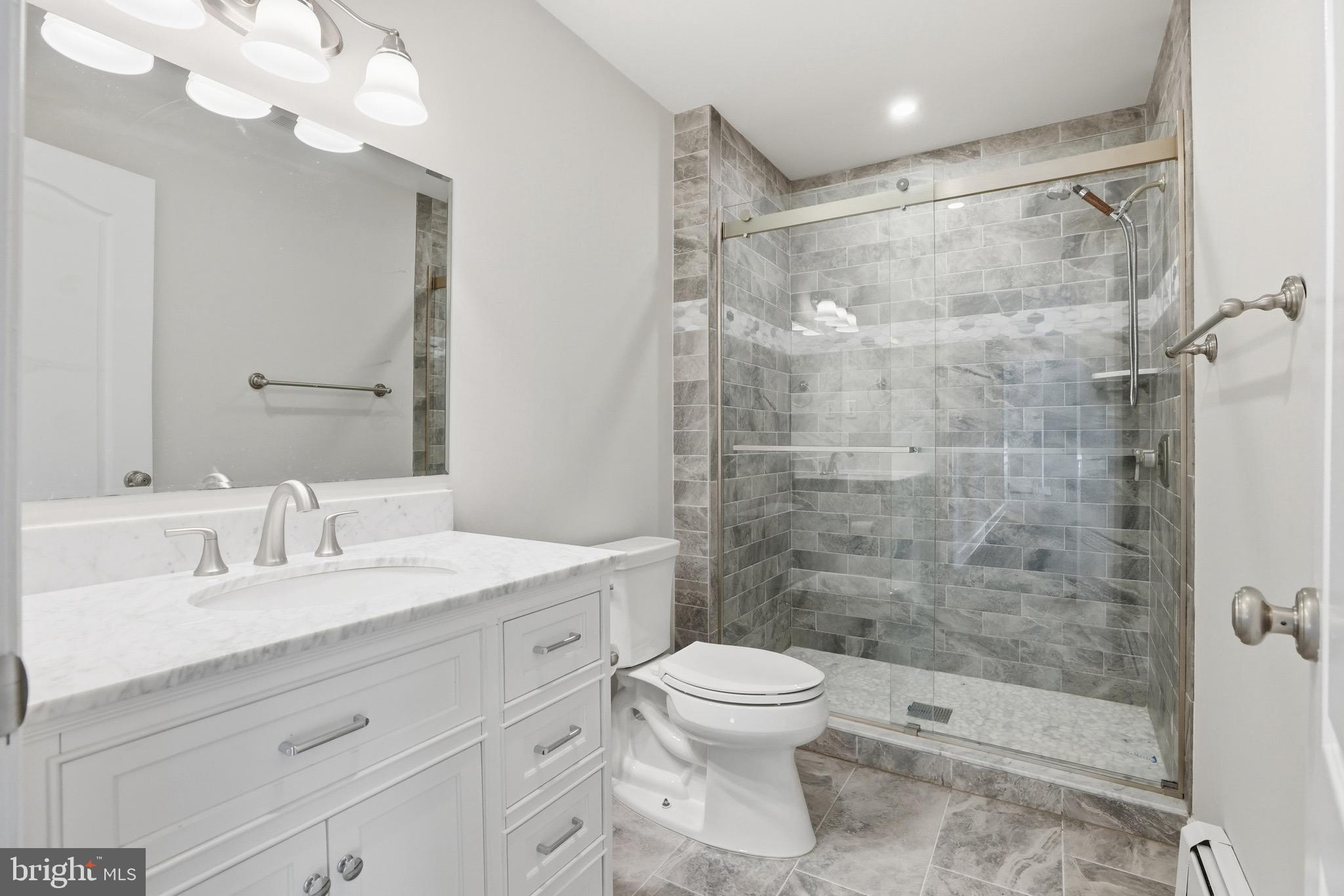 26410 Haines Road Clarksburg, MD 20871 - Photo 20 of 33 a bathroom with a shower sink vanity mirror and toilet