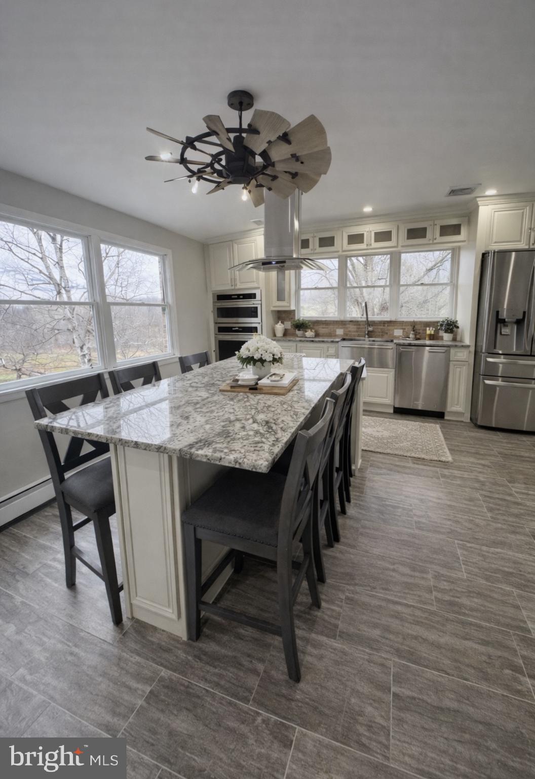 26410 Haines Road Clarksburg, MD 20871 - Photo 9 of 33 a kitchen with kitchen island a stove a table and chairs in it