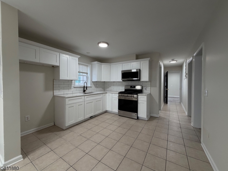167 North 5th Street, Unit 2 Paterson, NJ 07522 - Photo 3 of 8 a kitchen with granite countertop a sink a counter top space stainless steel appliances and cabinets