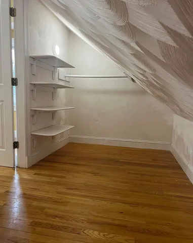 a view of a room with an empty space and wooden floor