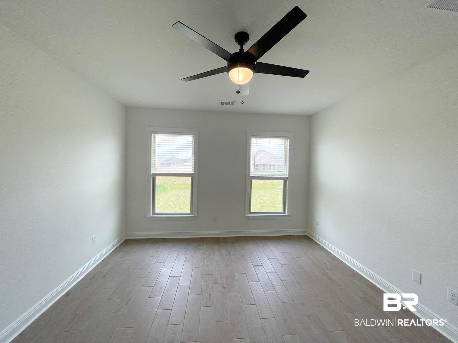 1339 Fenton Circle Foley, AL 36535 - Photo 8 of 17 Empty room with dark wood finished floors, visible vents, ceiling fan, and baseboards