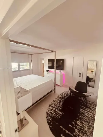 a bedroom with a bed window and mirror