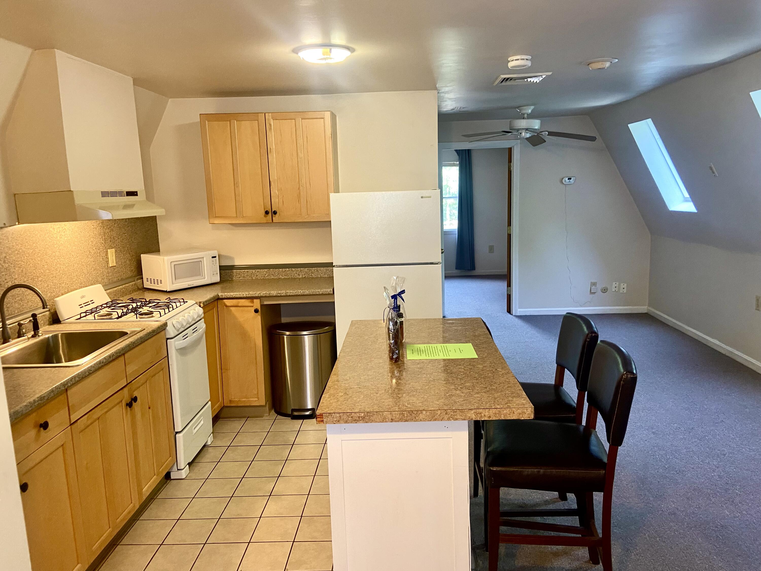 501 County Road Pocasset, MA 02559 - Photo 27 of 33 a kitchen with a sink a stove and chairs