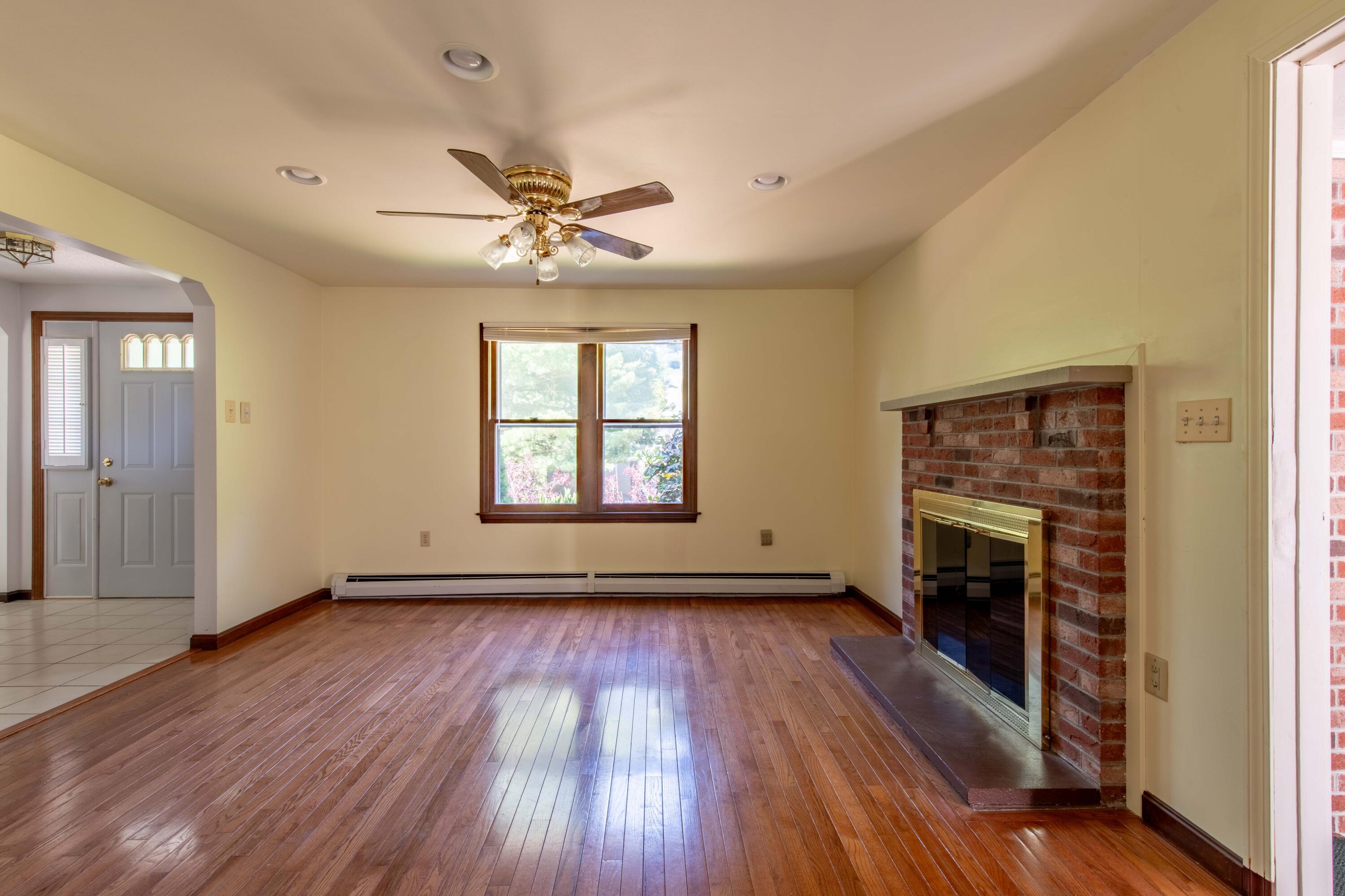 501 County Road Pocasset, MA 02559 - Photo 9 of 33 an empty room with windows fireplace and wooden floor