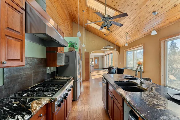 a kitchen with stainless steel appliances granite countertop a stove a sink dishwasher and a stove