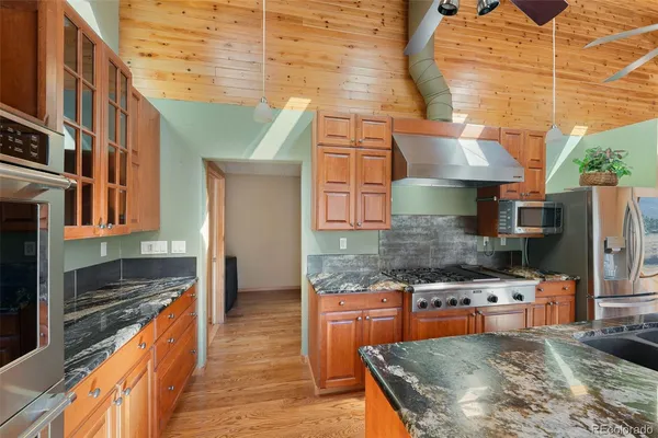 a kitchen with stainless steel appliances granite countertop a stove a sink and a refrigerator