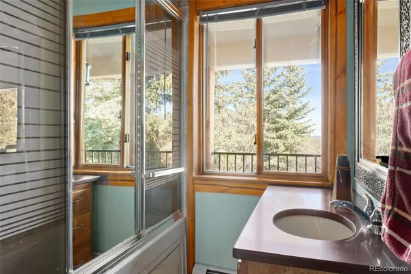 a bathroom with a sink a bathtub and next to a window