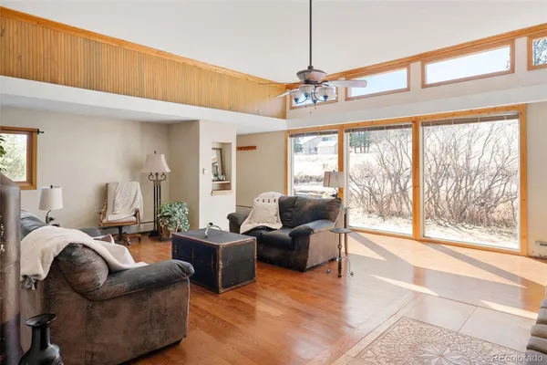 a living room with furniture ceiling fan and a window