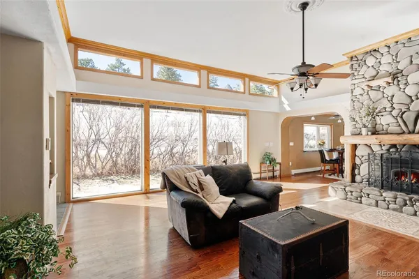 a living room with furniture a chandelier and a floor to ceiling window