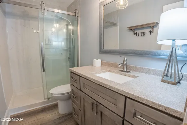 a bathroom with a sink a toilet and shower
