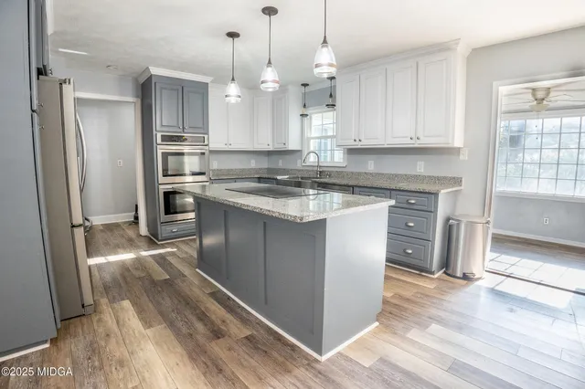 a kitchen with stainless steel appliances granite countertop a stove a refrigerator and a sink with granite countertops
