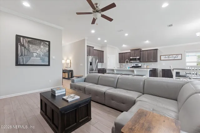 a living room with furniture and a view of kitchen