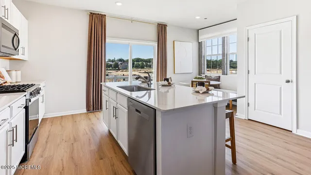 a kitchen with a sink stove and wooden floor